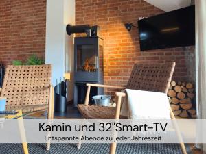 a living room with two chairs and a wood stove at HexenburgbeiDresden 2 Zimmer Architektenwohnung mit eigener Sauna, Whirlwanne und Kamin - Nähe Sächsische Schweiz Dresden in Großharthau