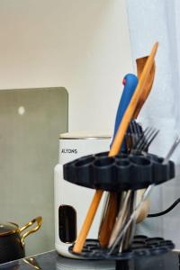 una tazza piena di utensili sopra un bancone di Kikuyu Thogoto Heights a Rungiri