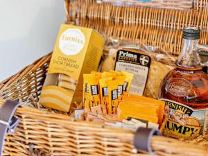 a basket filled with food and a bottle of alcohol at 1 Bed in Portreath 93858 in Redruth