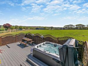 a hot tub on a deck with a picnic table at 1 Bed in Portreath 93858 in Redruth