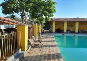 a swimming pool with two chairs next to a house at Hotel e Pousada Ciconha-são Lourenço MG in São Lourenço +91 photos