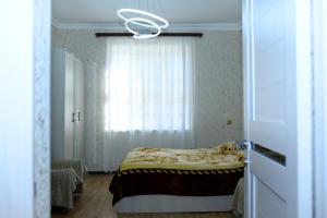 a bedroom with a bed and a window with a curtain at Vardanyan Family Guest House in Shnogh +19 photos