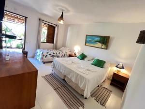 a bedroom with two beds and a large window at Pousada Pandoro in Trancoso
