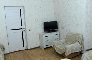 a living room with a tv and a chair at Vardanyan Family Guest House in Shnogh