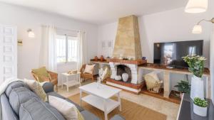 ein Wohnzimmer mit Couch und Kamin in der Unterkunft Casa Los Pinos Torrox by Ruralidays in Torrox