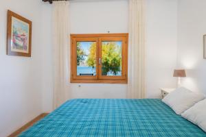 a bedroom with a bed and a window at Sa Marina in Alcudia