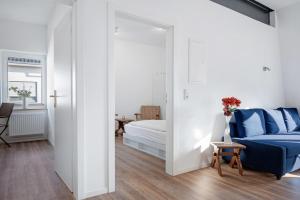 a bedroom with a king sized bed and a blue couch at Die Alter Schwede Wohnung 2 in Vechta