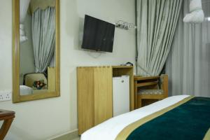a bedroom with a bed and a tv on the wall at Ridar Hotel in Seeta