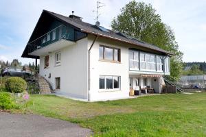 a white house with a black roof at Ferienwohnung im Haus Böll in Feldberg