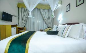 a bedroom with a large white bed and a television at Ridar Hotel in Seeta +22 photos
