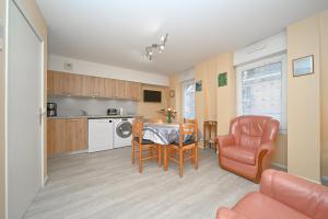 una cucina e una sala da pranzo con tavolo e sedia di Appartement centre ville Cauterets a Cauterets