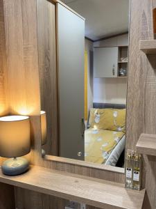 einen Spiegel in einem Zimmer mit einem Bett in einem Schlafzimmer in der Unterkunft Sutherland C14 in Lossiemouth