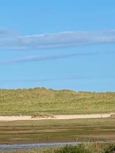 ein Feld mit einer Schotterstraße in der Ferne in der Unterkunft Sutherland C14 in Lossiemouth