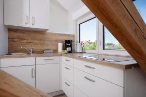 a kitchen with white cabinets and a window at Fewo Ferdl in Waltenhofen