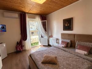 Un dormitorio con una cama grande y una ventana grande. en Panoramic terace Victory boutique, en Bucarest