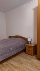 Un dormitorio con una cama y una mesita de noche con una lámpara. en Квартира у реки, en Riga