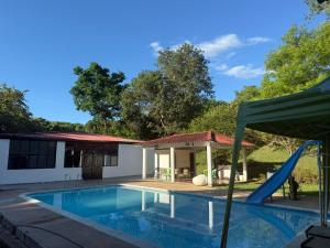 una piscina con scivolo accanto a una casa di Finca El Encanto a Agua de Dios