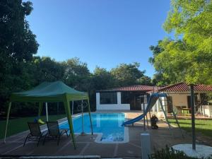 una piscina con scivolo e un parco giochi di Finca El Encanto a Agua de Dios