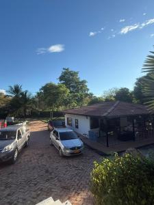 due auto parcheggiate in un parcheggio di fronte a una casa di Finca El Encanto a Agua de Dios