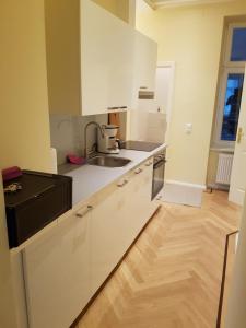 una cucina con armadi bianchi e lavandino di Ableidinger Apartments a Vienna