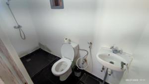 a bathroom with a white toilet and a sink at Riad Bladi Essaouira in Essaouira
