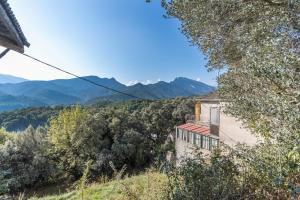 an old house on a hill with mountains in the background at Casa Pirinea in Belsierre