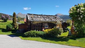 a small wooden house with mountains in the background at Residence Condor Apt Eidechsspitz in Maranza +18 photos