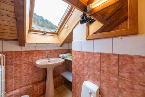Un baño con lavabo y ventana. en Appt 4 pers-chalet l'ancienne école, en La Bresse