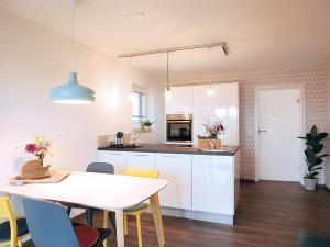 eine Küche und ein Esszimmer mit einem weißen Tisch und Stühlen in der Unterkunft Kleine Auszeit in Thalheim