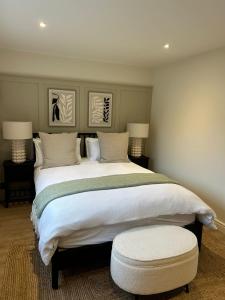 a bedroom with a large white bed with a ottoman at Newditch Farm - BRS Airport in Bristol