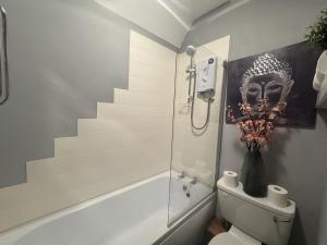 Un baño con ducha y WC y una escalera. en The Cosy Neuk, Hawick, en Hawick 4 fotos más