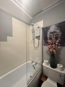 Un baño con ducha, inodoro y bañera. en The Cosy Neuk, Hawick, en Hawick