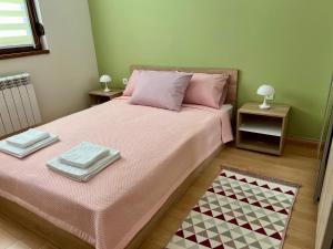 Un dormitorio con una cama con dos toallas encima. en Urban Taft Stay Skopje-Vodno View Suite with Underground Parking, en Skopje