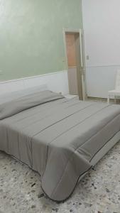 Cama grande en habitación blanca con colcha en Alabostreet51, en Augusta