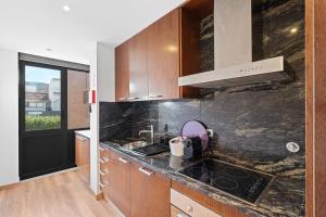 a kitchen with wooden cabinets and a counter top at GuestReady - Moledo's beach and sun in Santana