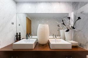 a bathroom with two white sinks and a mirror at GuestReady - Moledo's beach and sun in Santana