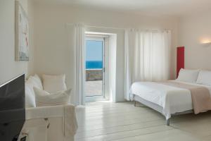 a bedroom with a bed and a view of the ocean at Villa Coventina - Family Residence in Agios Ioannis Mykonos