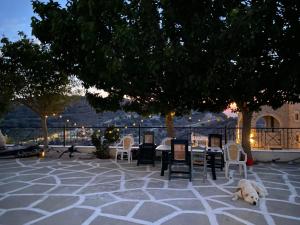 a dog laying on a patio with chairs and tables at Spitiko Apartment 1 in Kamilari