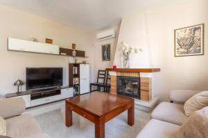 ein Wohnzimmer mit Tisch und Kamin in der Unterkunft Villa Eden Nerja in Nerja