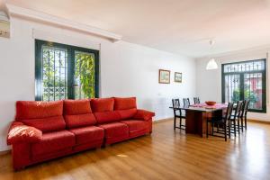 a living room with a red couch and a table at Villa Mascota Rincón de la Victoria in Rincón de la Victoria