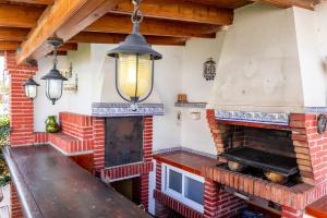 a patio with a brick fireplace and a wooden table at Villa Mascota Rincón de la Victoria in Rincón de la Victoria