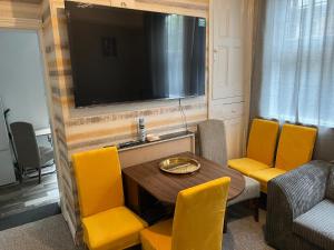 a living room with a table and chairs and a television at Spacious 7-Bedroom Victorian House in Darlaston