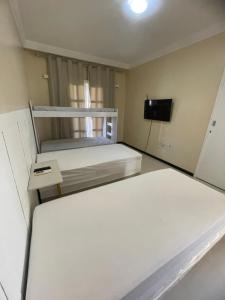 Un dormitorio con dos literas y un televisor. en Hostel beach, en Aracaju 30 fotos más