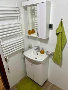 Un baño blanco con lavabo y espejo. en Urban Taft Stay Skopje-Vodno View Suite with Underground Parking, en Skopje 27 fotos más