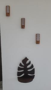 a white wall with three pieces of art on it at Le jardin in Puerto López