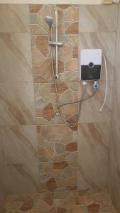 a shower in a bathroom with a stone wall at Le jardin in Puerto López