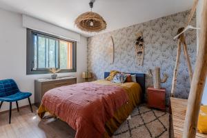 a bedroom with a bed and a blue chair at Villa avec Piscine La Teste de Buch in La Teste-de-Buch +23 photos