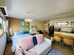 Un dormitorio con una cama y una sala de estar. en IMPACT challenger ห้องพักรายวัน เมืองทองธานี ตึก C9, P2, P1 每日房, en Nonthaburi