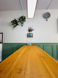 Una gran mesa de madera en una habitación con dos plantas en IMPACT challenger ห้องพักรายวัน เมืองทองธานี ตึก C9, P2, P1 每日房, en Nonthaburi