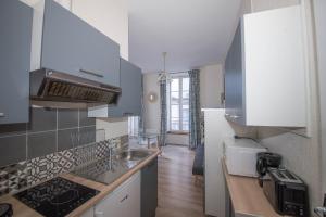 een keuken met een spoelbak en een aanrechtblad bij Le 14 De Pic in Cauterets +1 foto